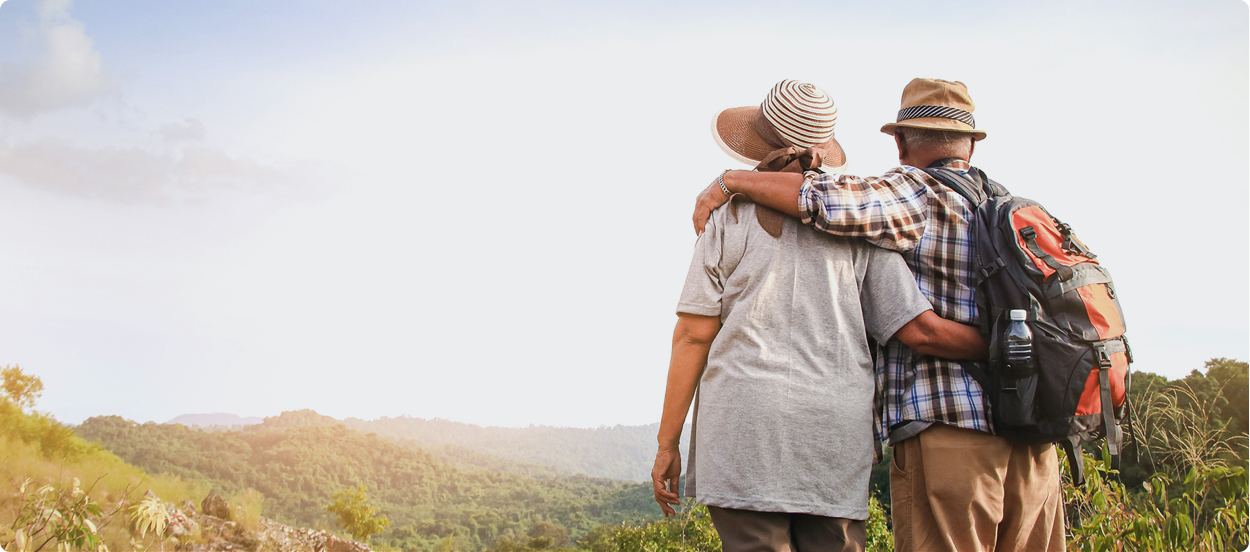 Elderly couple embracing, looking at a view ahead of them