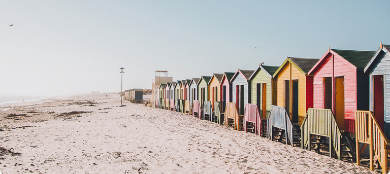 Multiple beach huts sitting on the beach